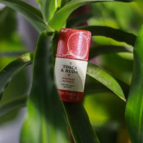 Labial rojo de remolacha con oxido rojo, en fondo de plantas verdes